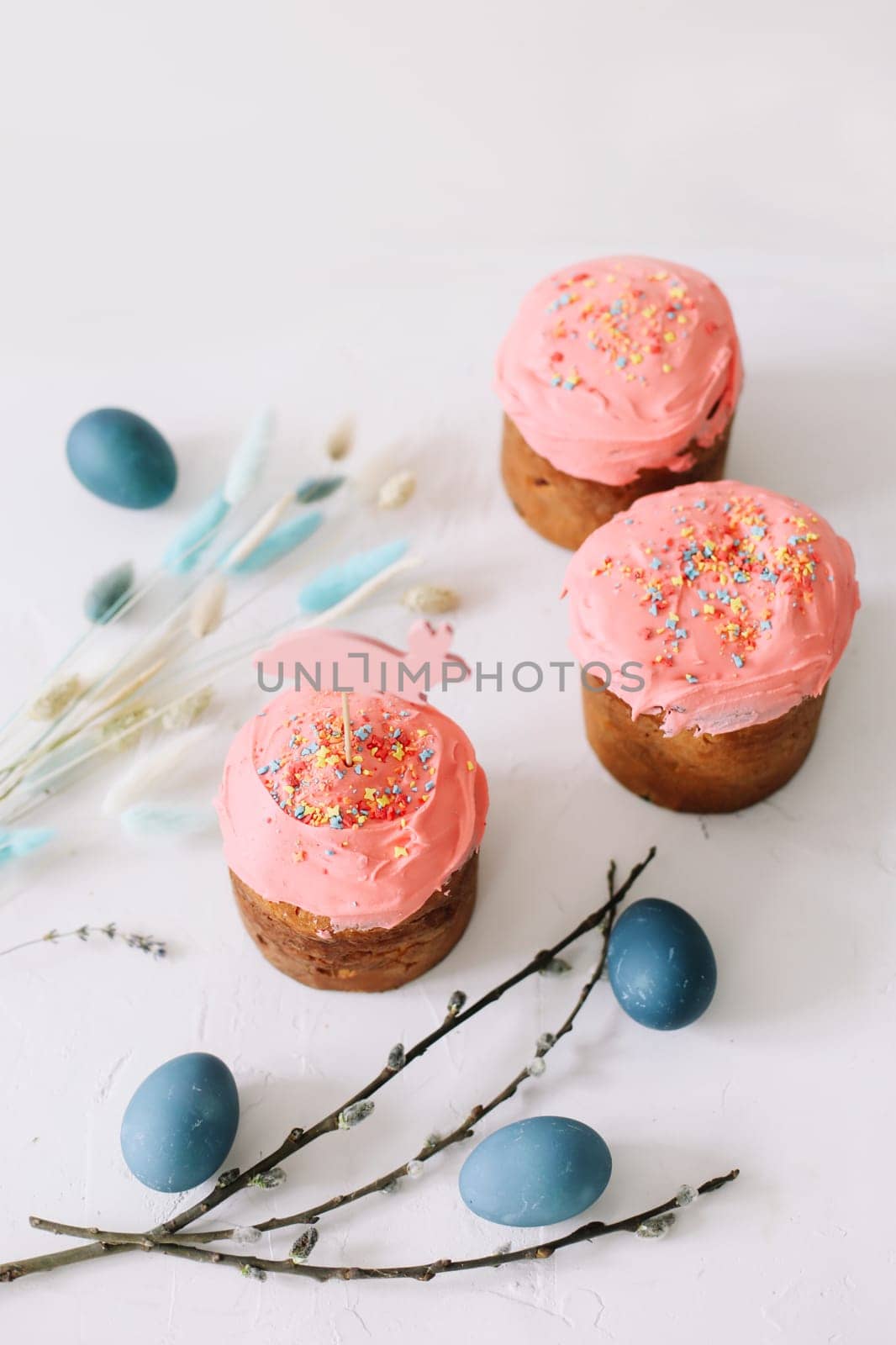 Plate with tasty Easter cake, eggs and willow branches on dark background. High quality photo