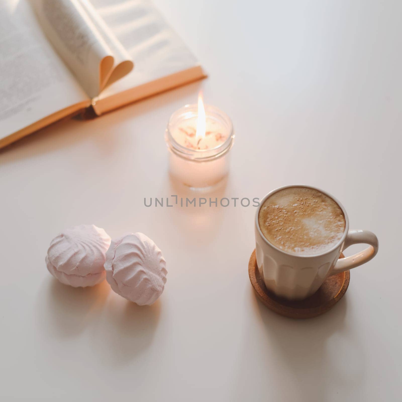 coffee cup, cotton flower, open book on a white table background top view. minimal home interior decor.