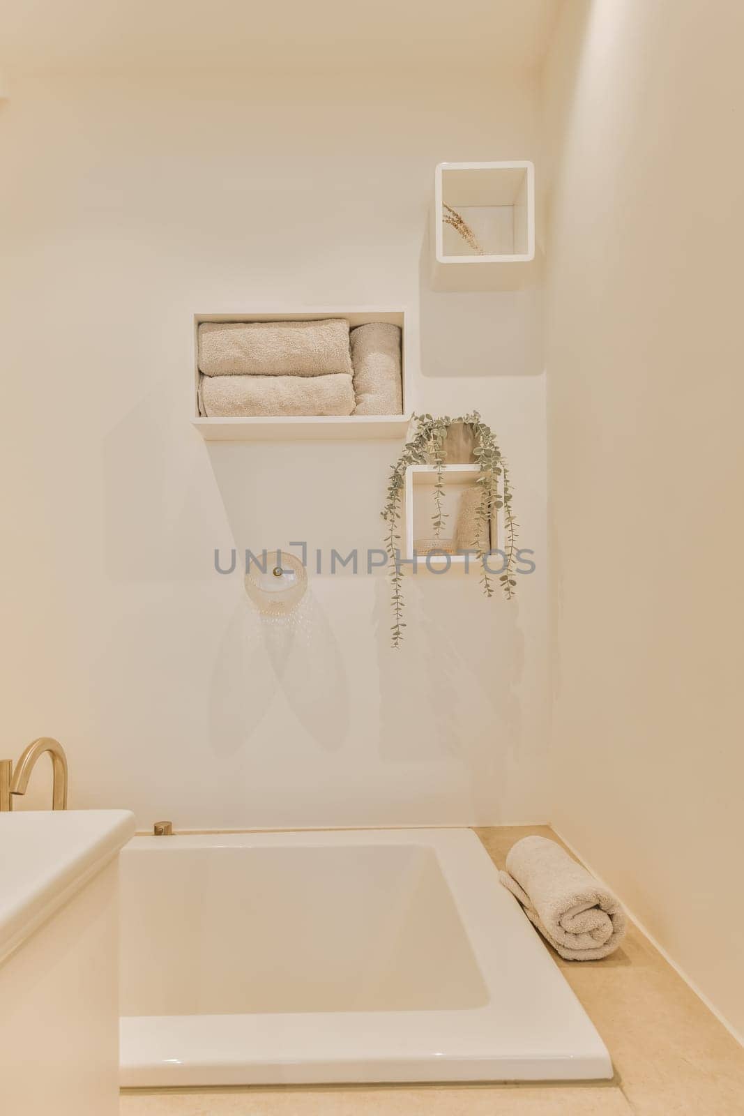 a bathroom with shelves on the wall and a white bathtub in the tub is filled with towels, soaps and other items