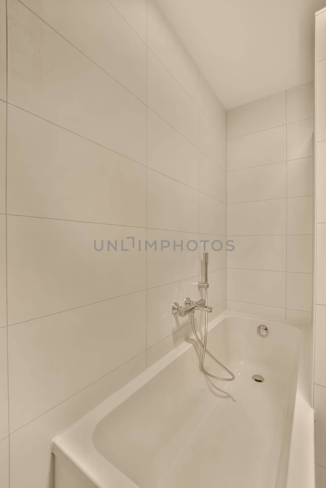 a white bath tub in a bathroom with white tiles by casamedia
