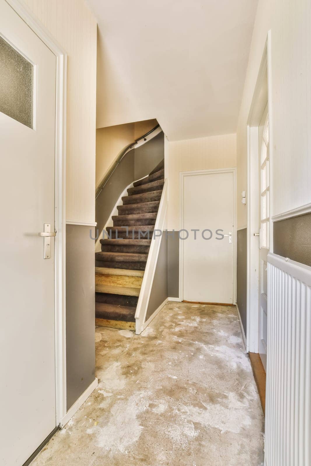 a hallway with stairs and a door and a door by casamedia