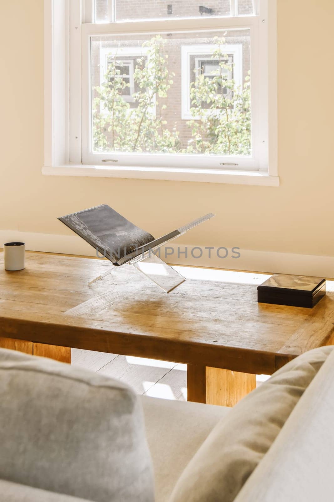 a laptop sitting on a coffee table in front of a window with a view of the city outside and inside