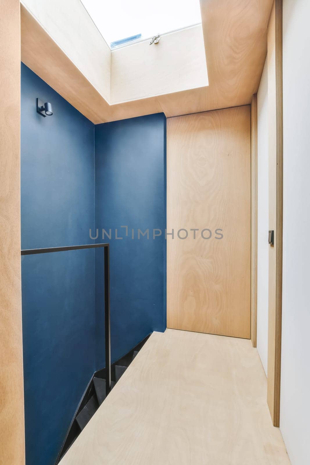 an empty room with blue walls and wood paneling on the walls, there is a skylight in the ceiling