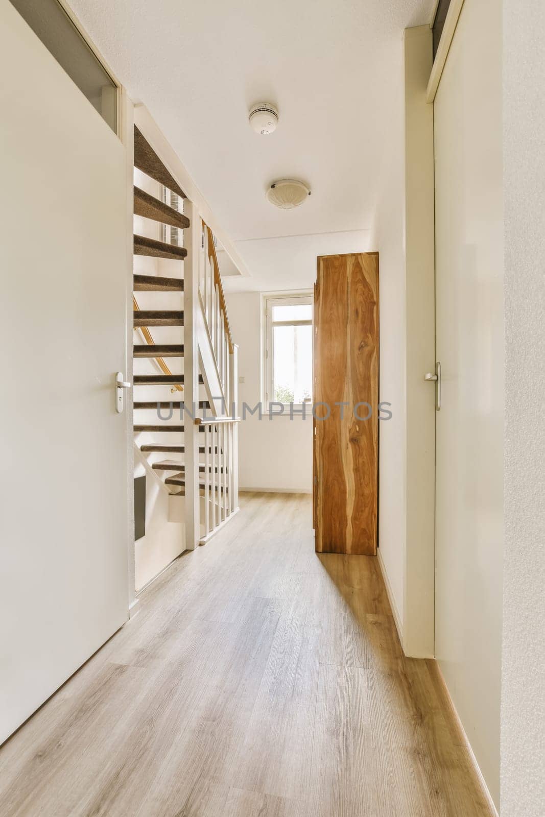 a hallway with a wooden door leading to a staircase by casamedia