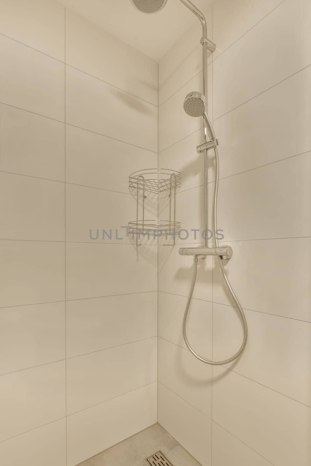 a shower room with white tile walls and beige tiles on the wall, there is a basket in the shower