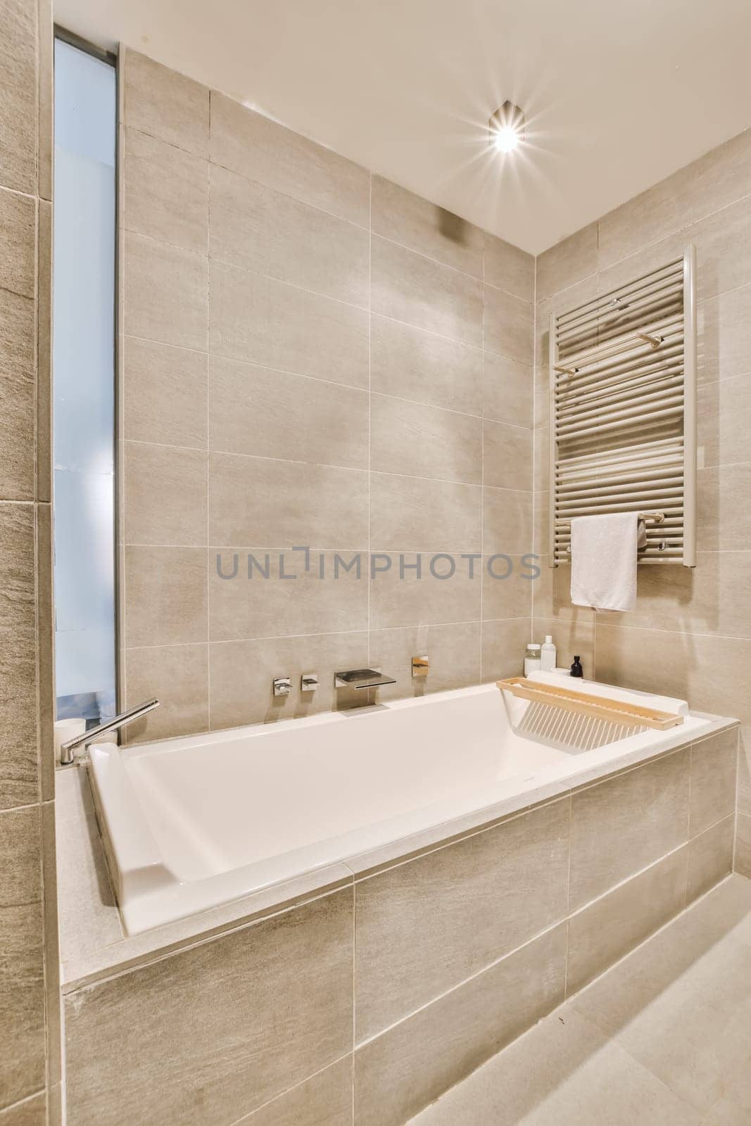 a bathroom with a bathtub and towel rack on the wall next to the tub that is in front of the window