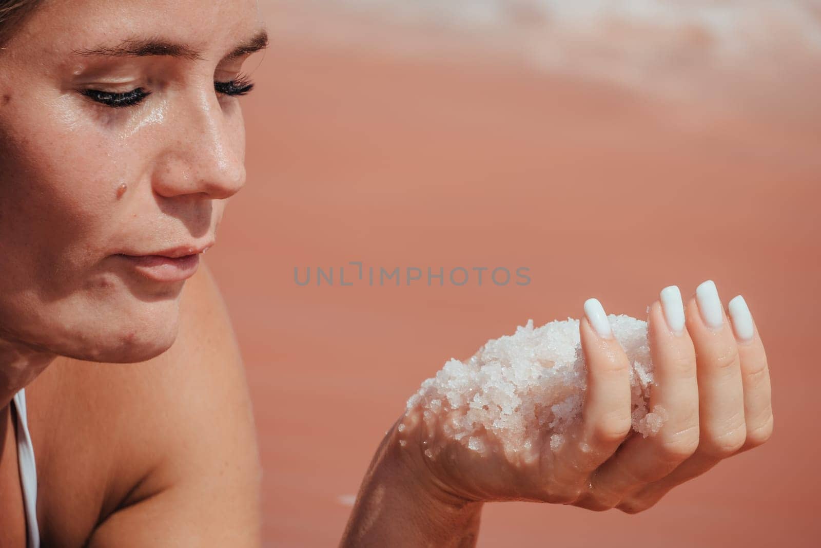 Salt mining. Salty pink lake with crystals of salt. Extremely salty pink lake, colored by microalgae with crystalline salt depositions