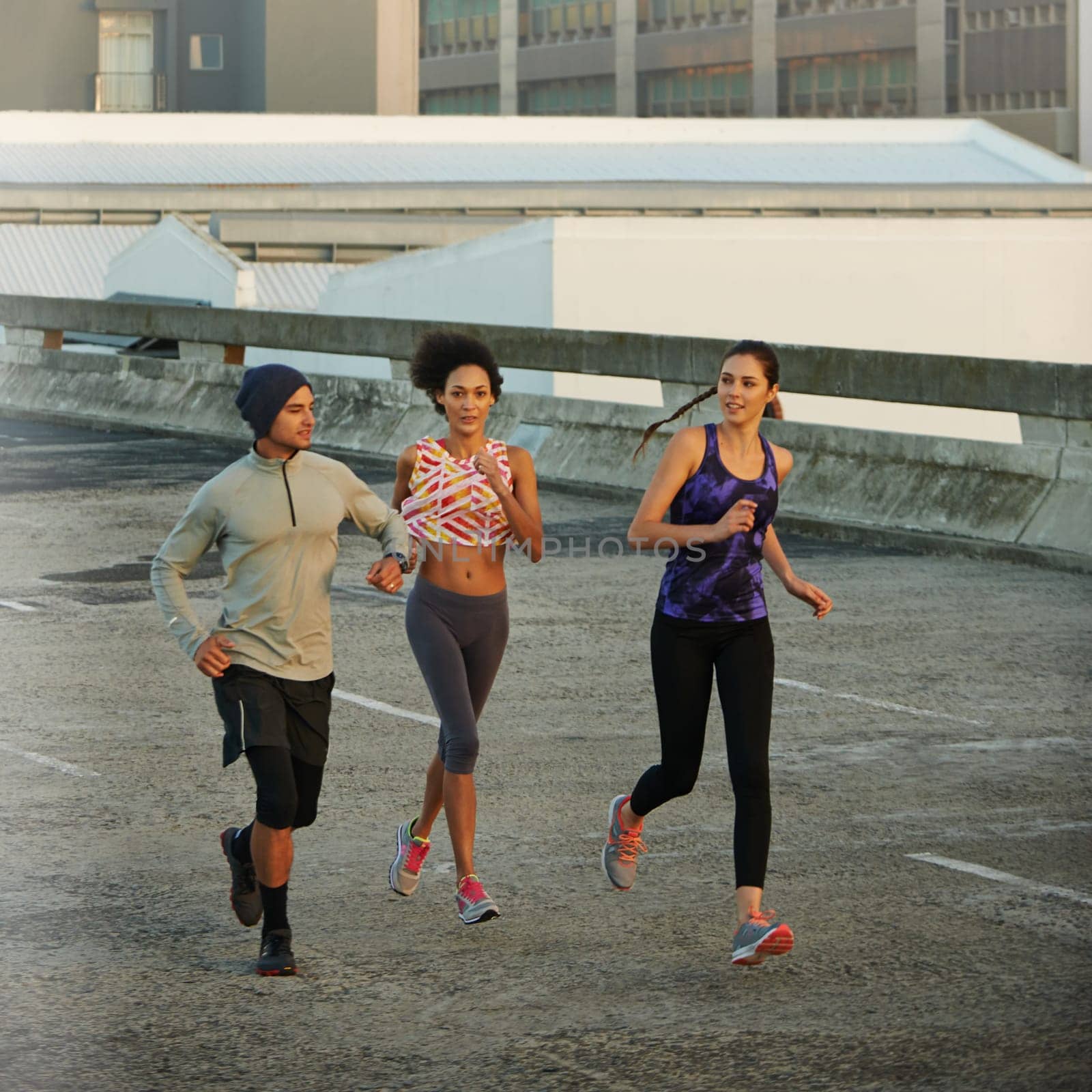 They love an early morning run. joggers running down an empty highway in the morning