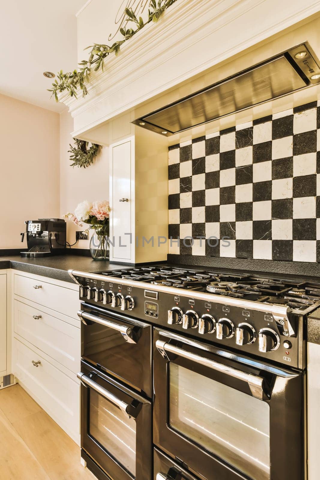 a kitchen with black and white tiles on the backs of the stoves, oven and dishwasher in it