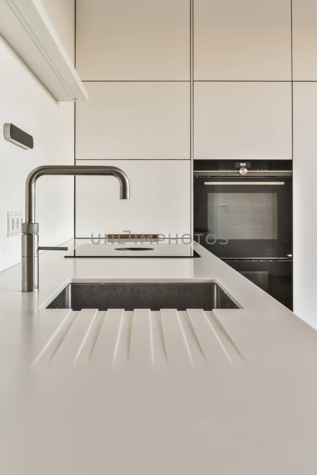 a modern kitchen with white counters and black appliances on the wall in this photo is taken from the inside