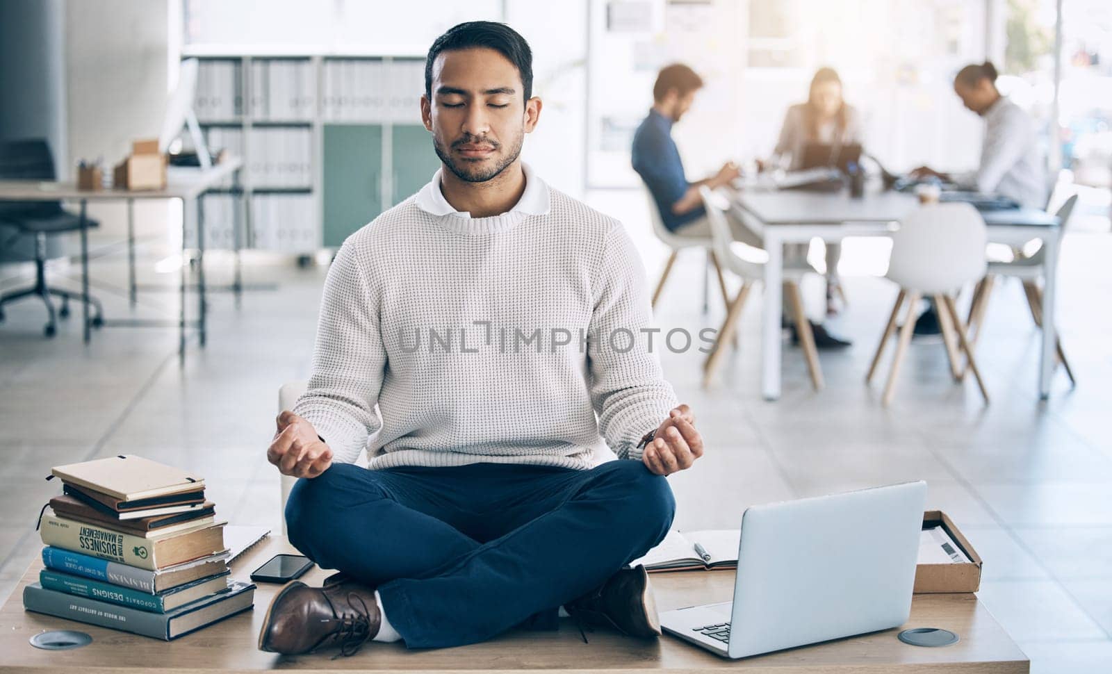 Meditation, relax or businessman with laptop, books or zen peace in office desk for work mindset, wellness or mental health. Corporate, employee or Asian man relaxing, meditating or lotus pose by YuriArcurs