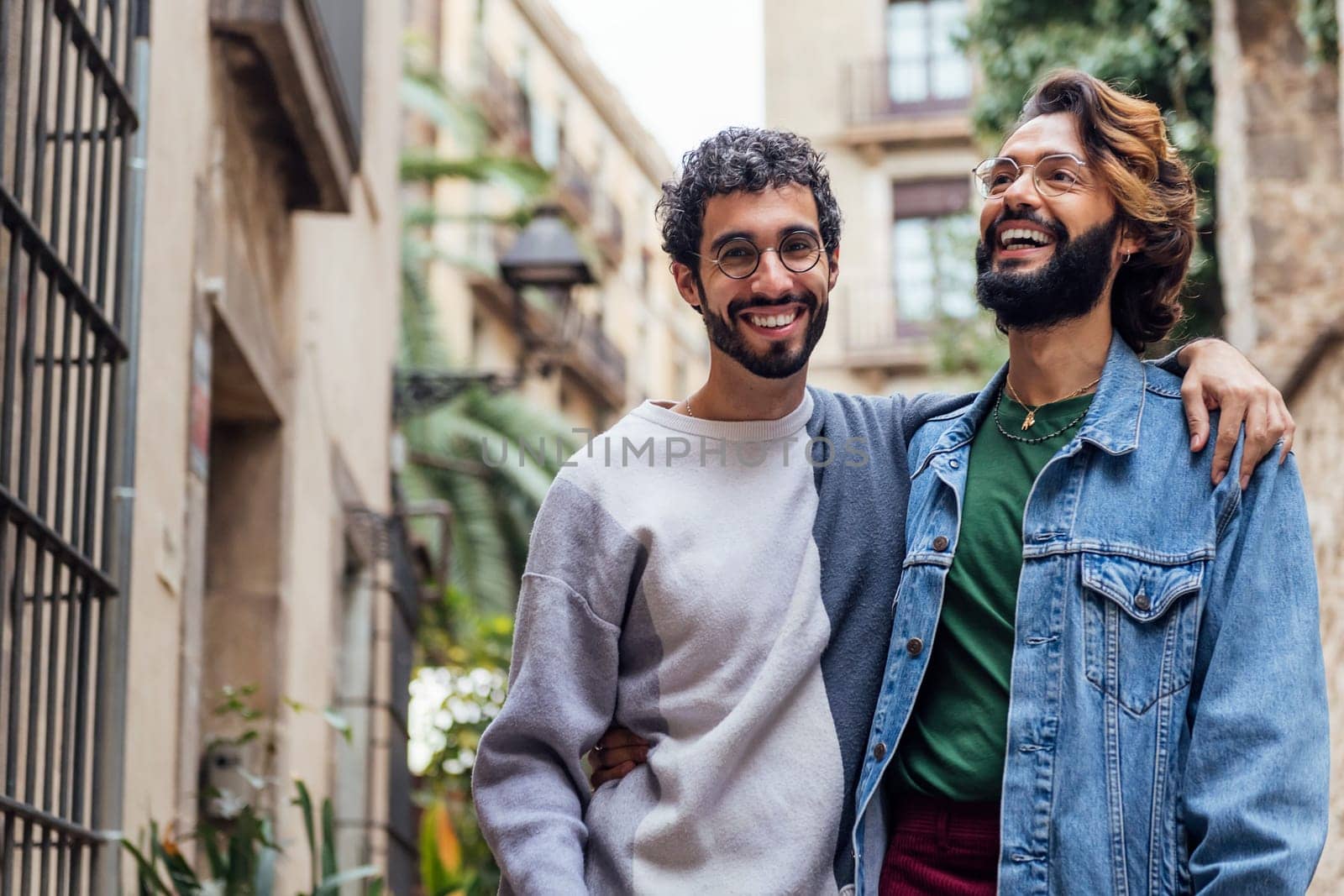 gay male couple embracing smiling happy in the street, concept of leisure and love between people of the same sex, copy space for text