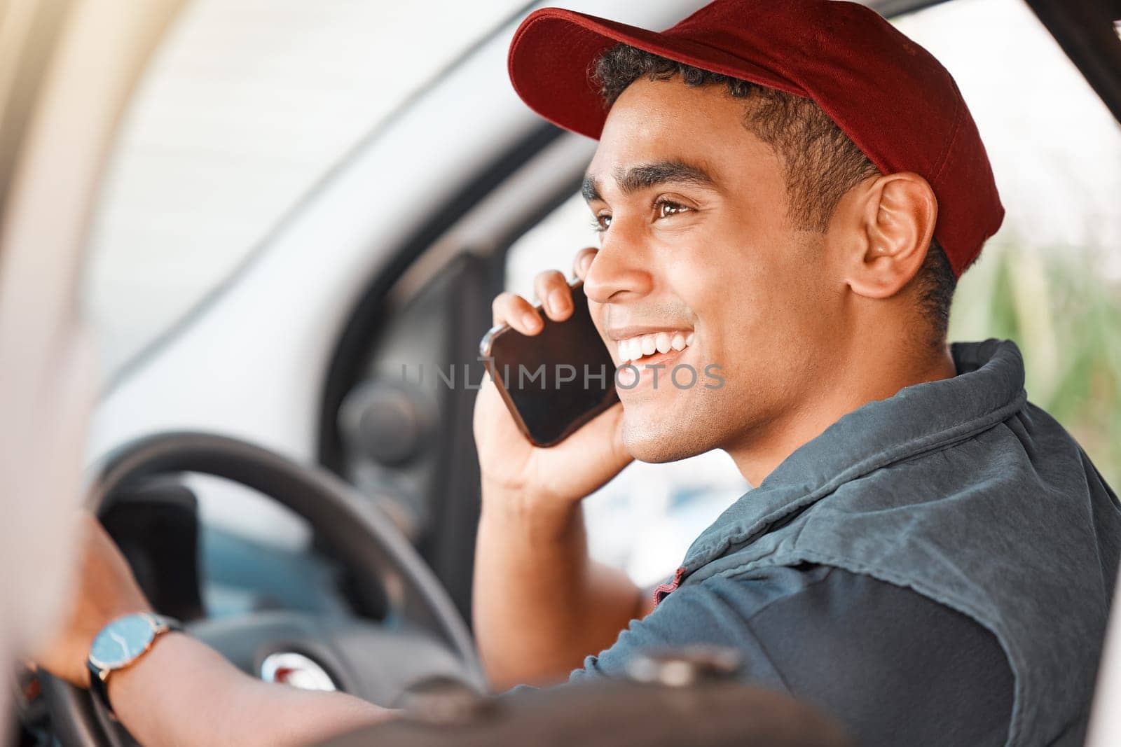Phone call, driving and courier talking on a mobile while doing a delivery. Happy, young and driver working in logistics, ecommerce or transportation industry speaking on a smartphone in a car by YuriArcurs