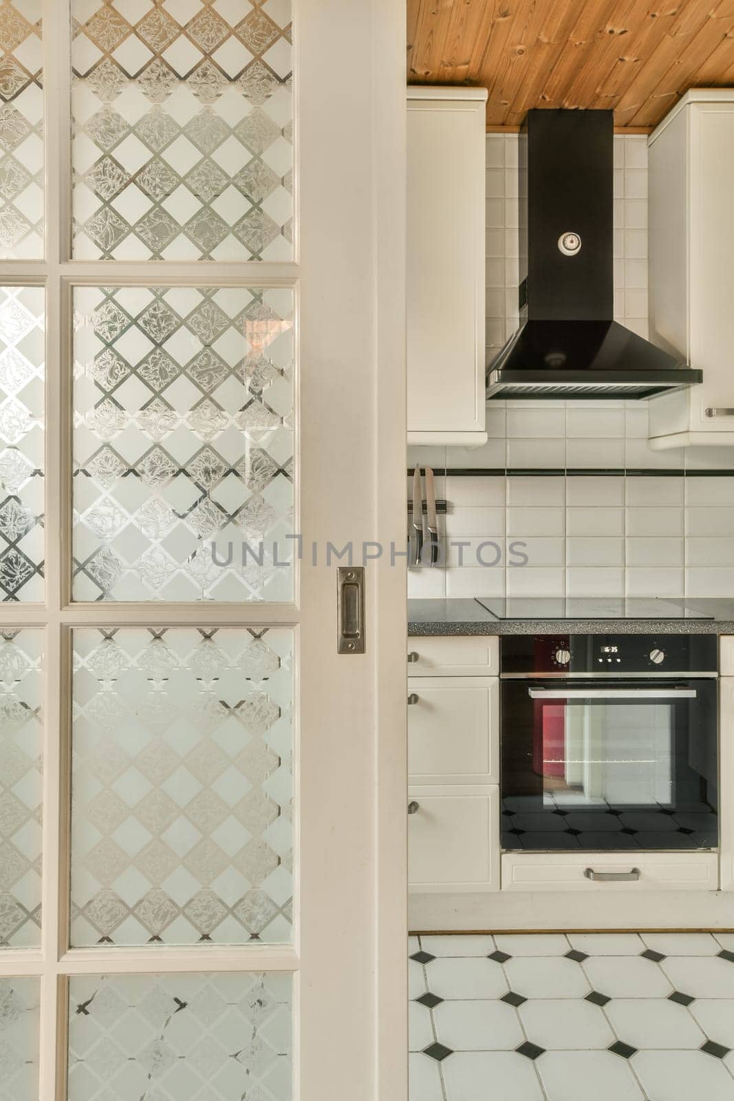 a kitchen with white cabinets and a glass door by casamedia