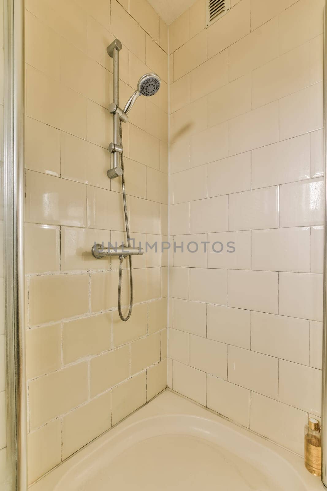 a shower with a shower head in a white bathroom by casamedia