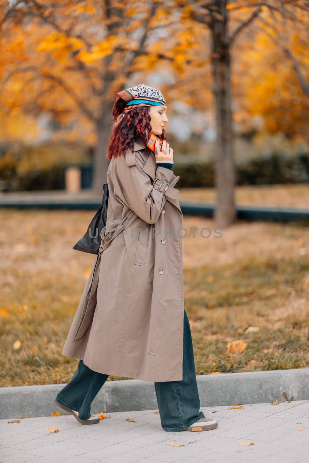 A woman walks outdoors in autumn, enjoys the autumn weather