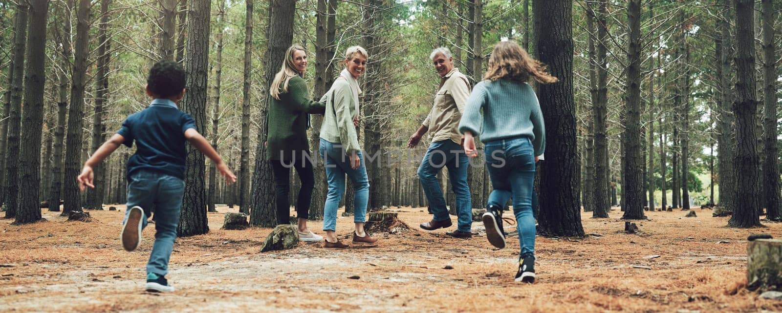Forest, big family and adventure with children, parents and grandparents walking in nature for outdoor hiking, fun and trees on wellness vacation. Running kids, travel and happy man and women in wood.