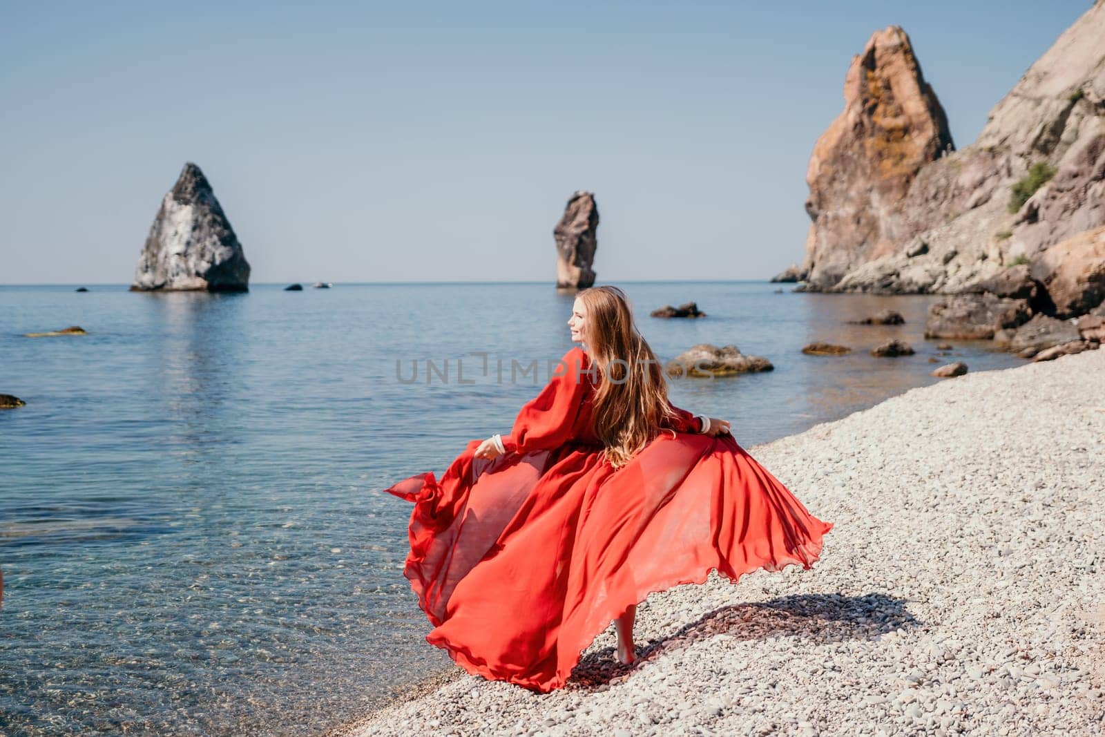 Woman travel sea. Happy tourist taking picture outdoors for memories. Woman traveler looks at the edge of the cliff on the sea bay of mountains, sharing travel adventure journey.