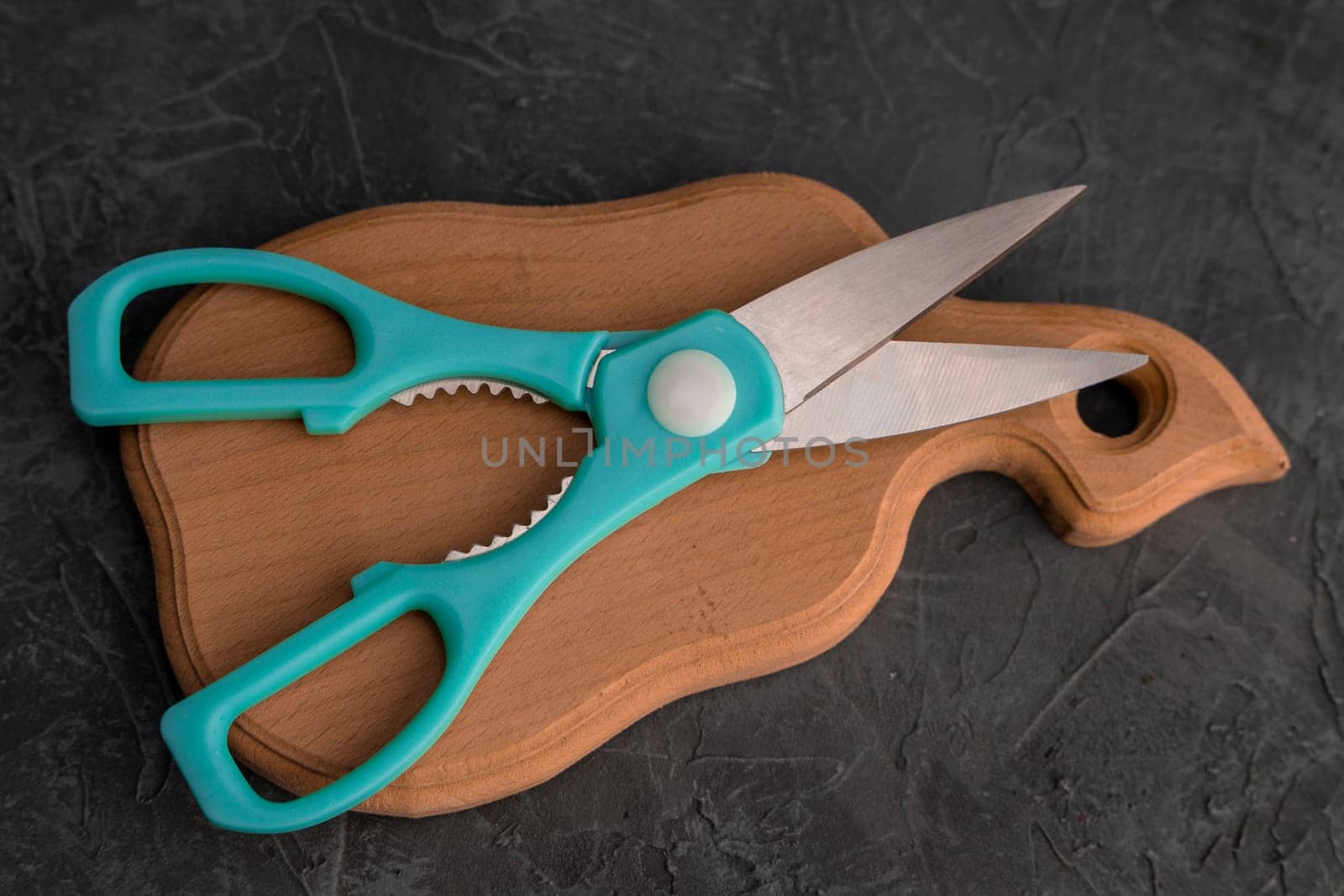 sharp kitchen scissors on a wooden cutting board in the kitchen. Close-up of kitchen accessories. cooking. Healthy eating. The cook's job. top view