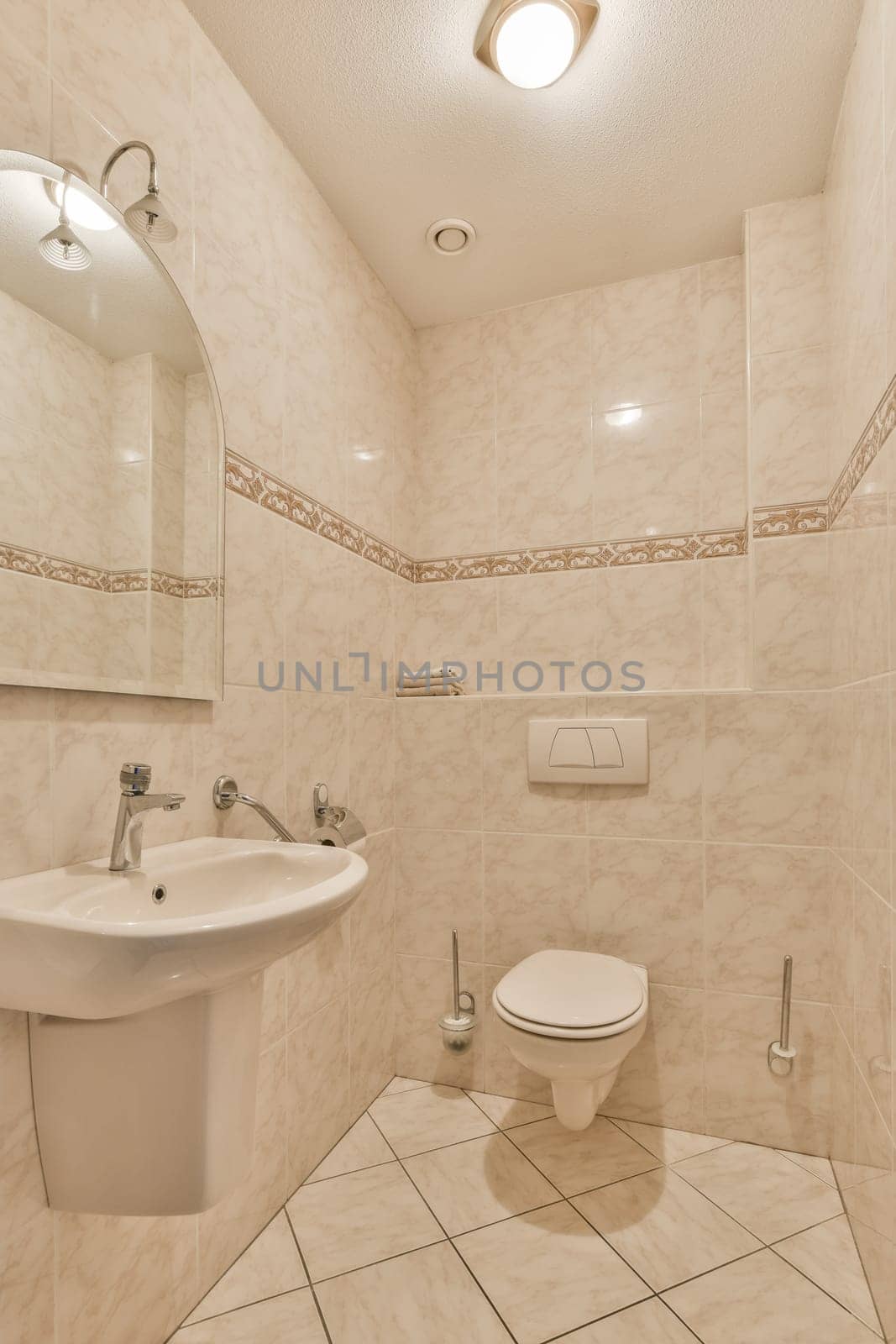 a bathroom with tiled walls and white tiles on the floor, there is a toilet in the corner next to the sink