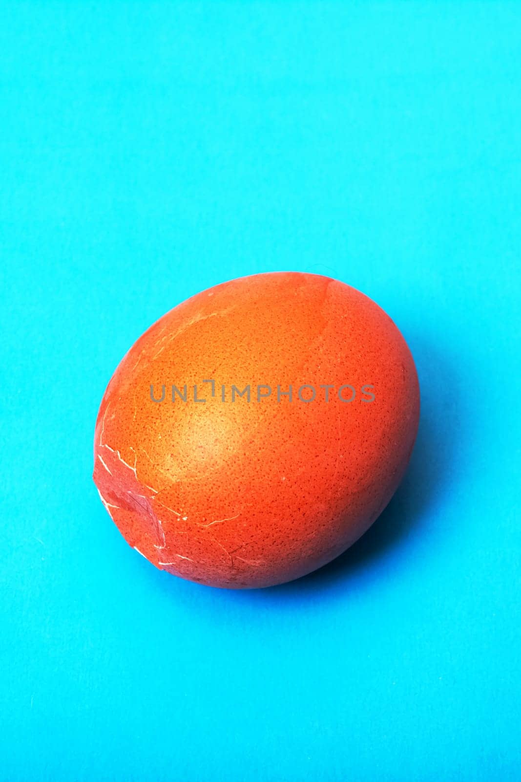 Brown cracked egg on a blue background, copy space