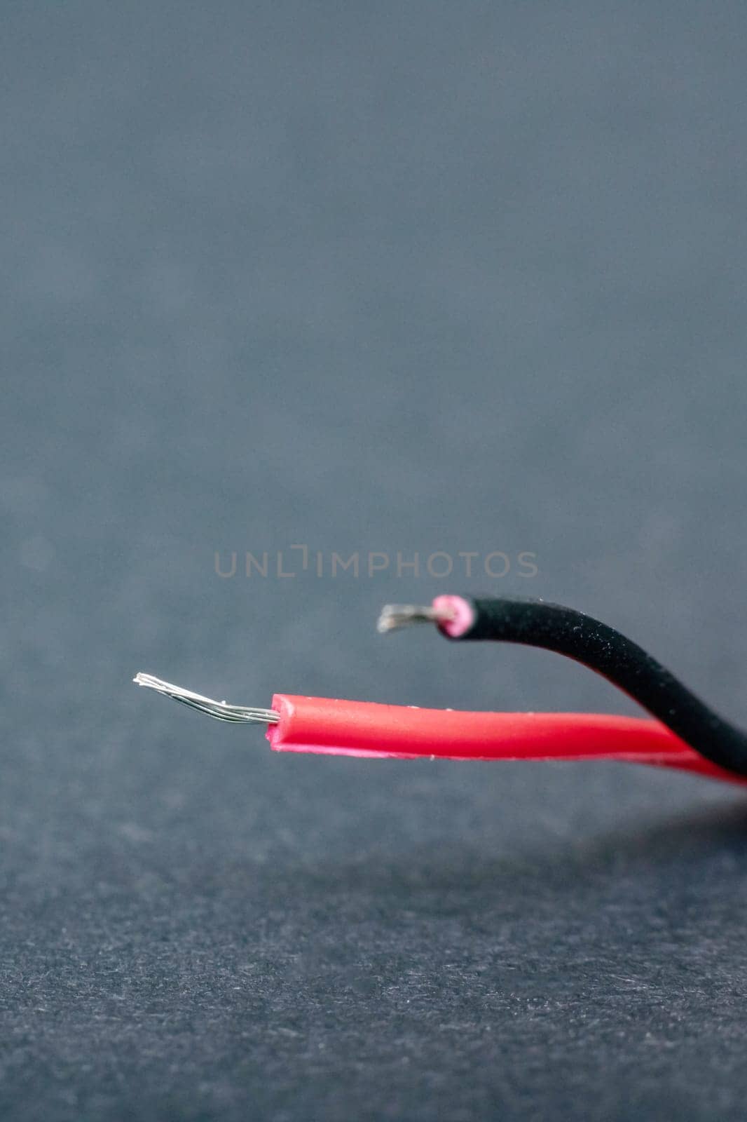 Bared red wire on a black background close up
