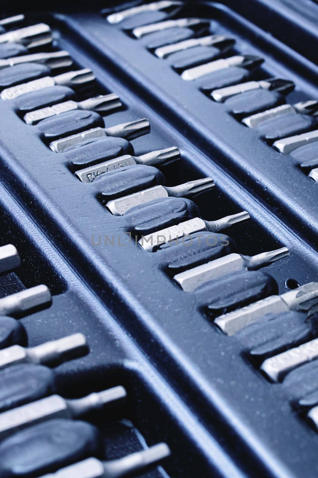 Black plastic box with bits for screwdriver close up, background