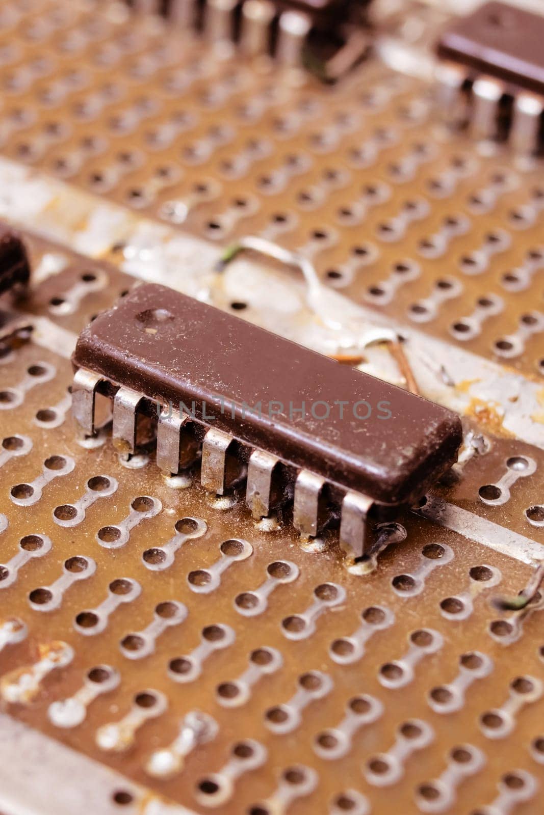 Old dirty yellow circuit board with transistors close up