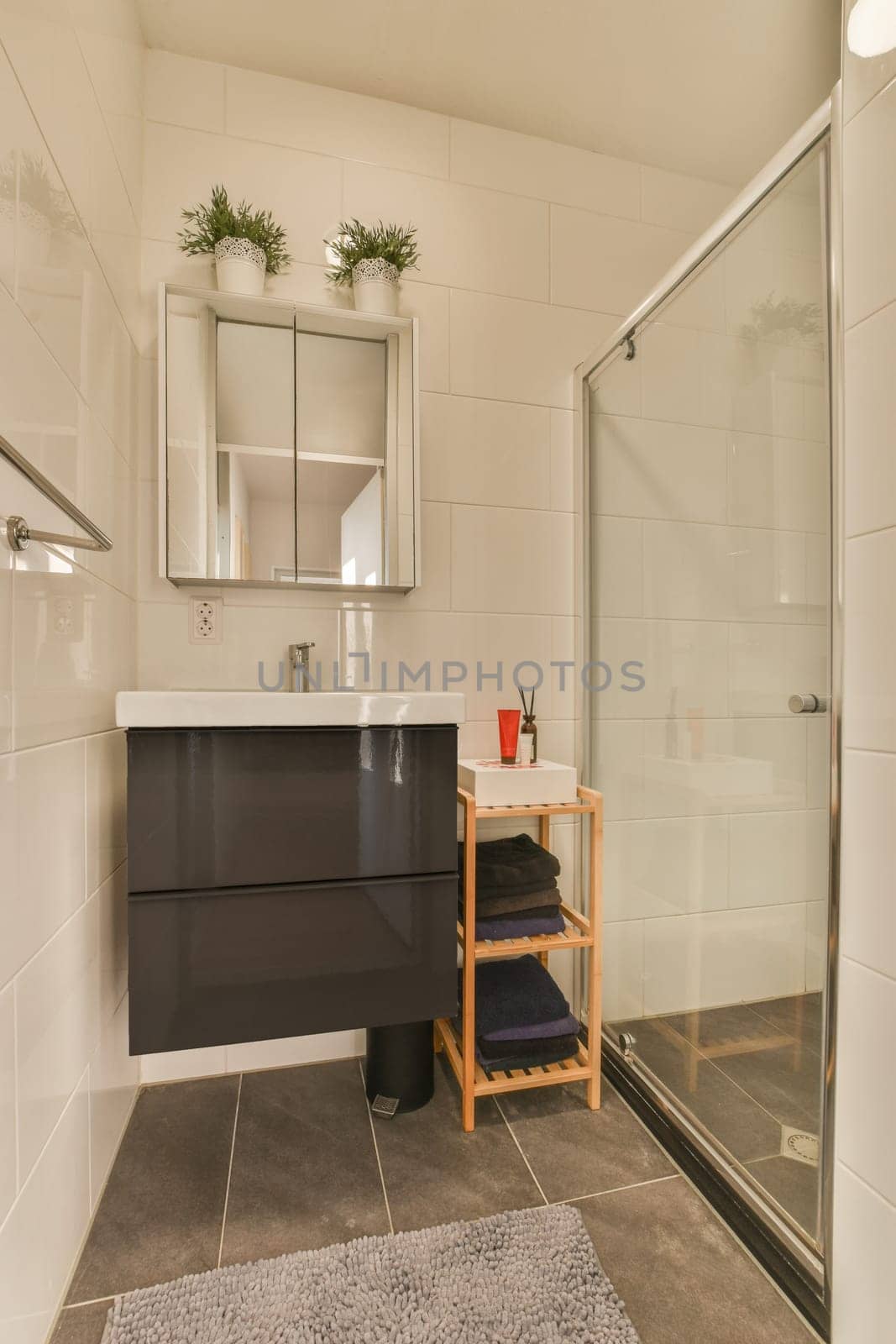 a modern bathroom with black and white tiles on the floor, shower stall and toilet in the background is tiled