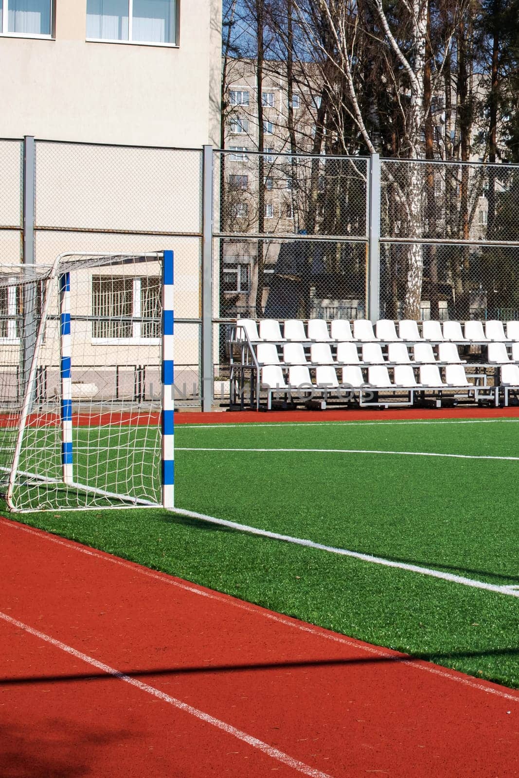 Green soccer field behind the fence close up