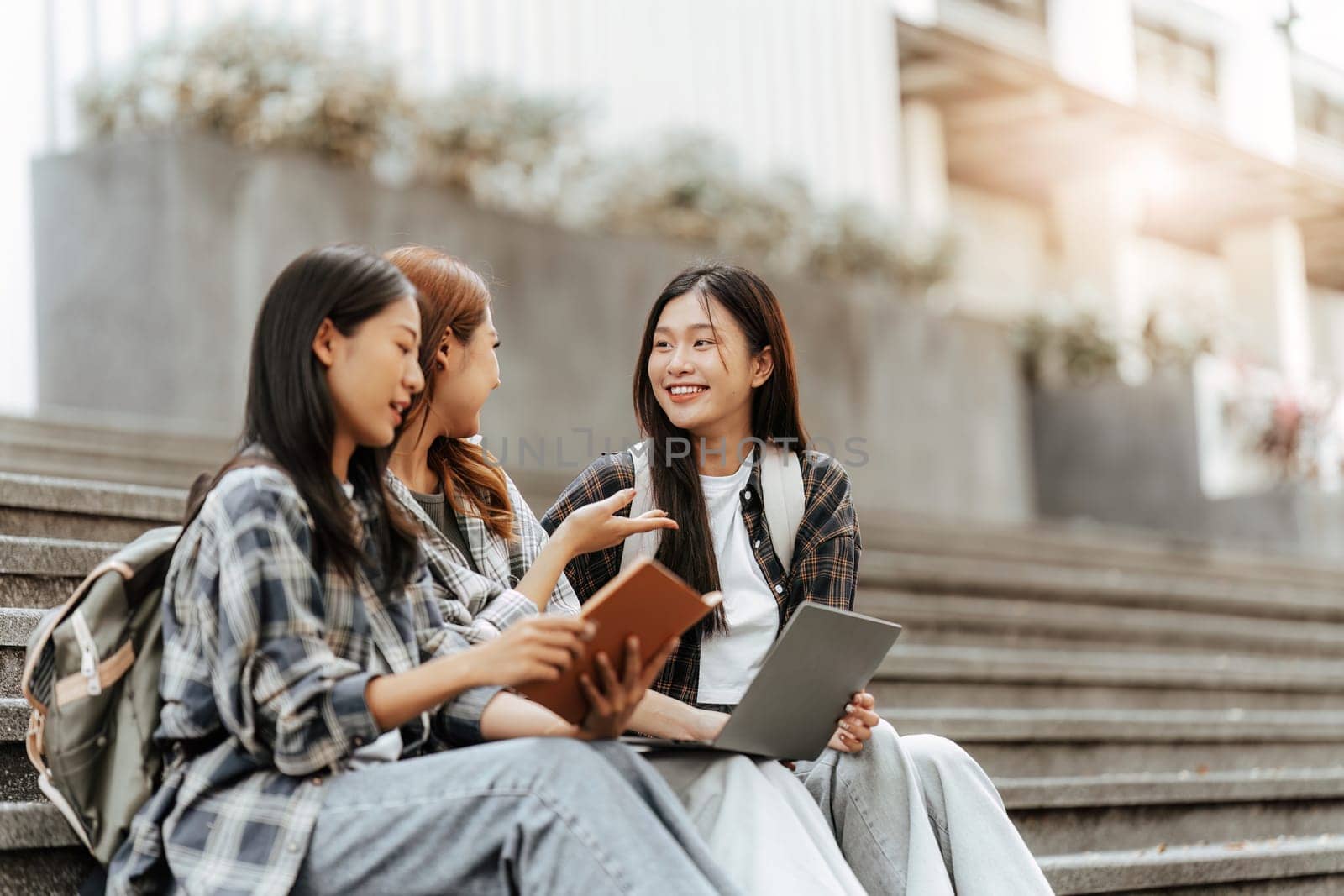 Young Asian woman college student with friends at outdoors. College student working on the college campus, education, school, study by itchaznong