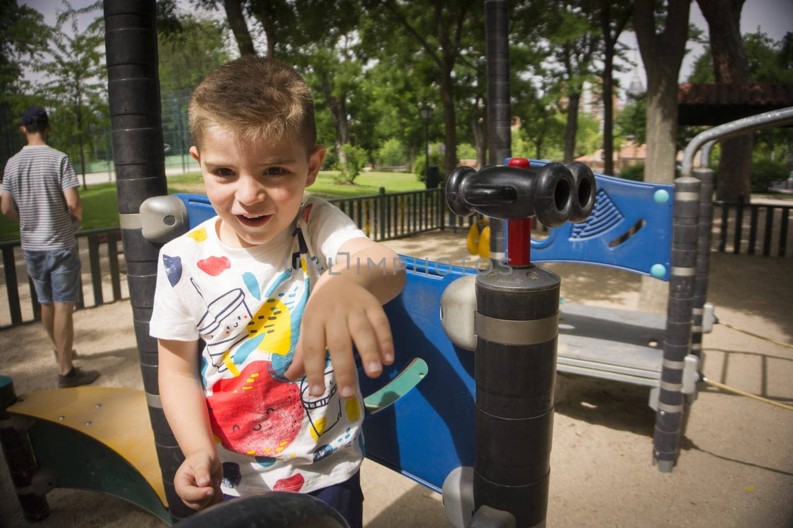 Four year old boy playing in a playground. Summer day