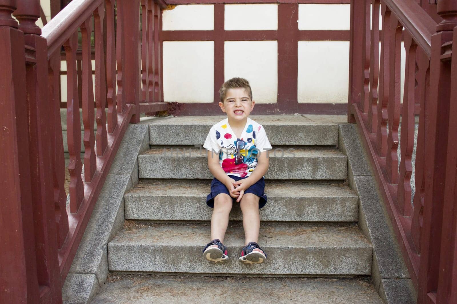 Four year old boy sitting gesturing. Alone