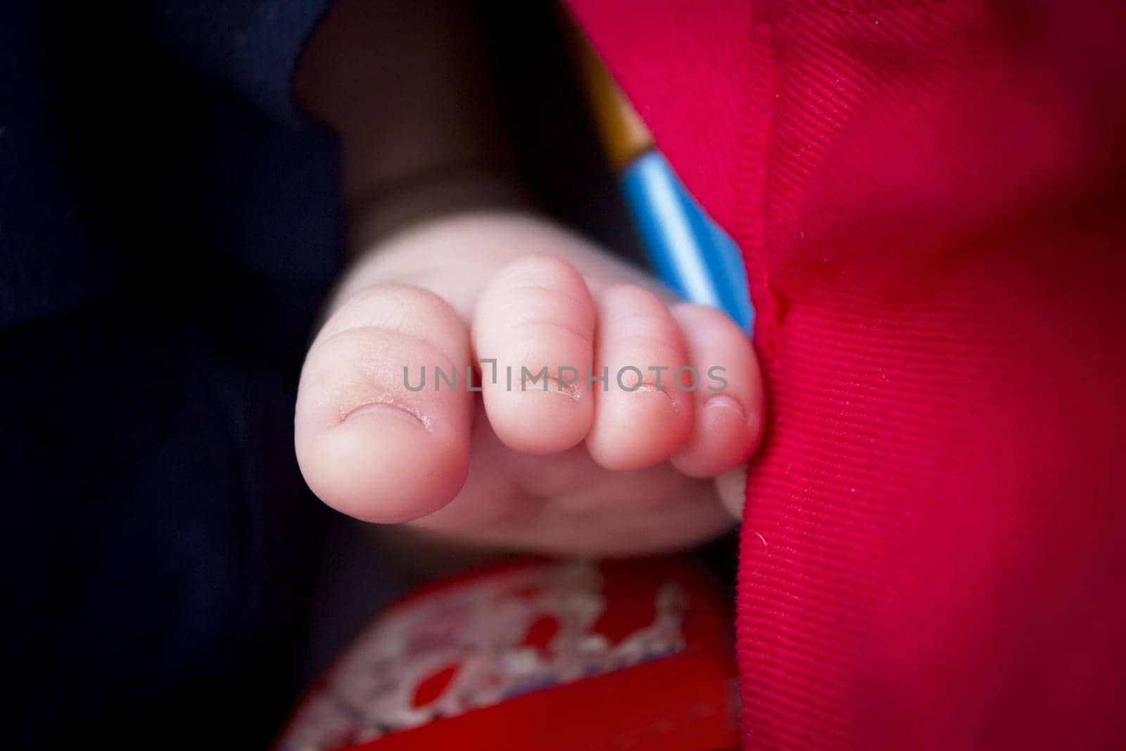 Two month old baby feet on black background. Sweet scene