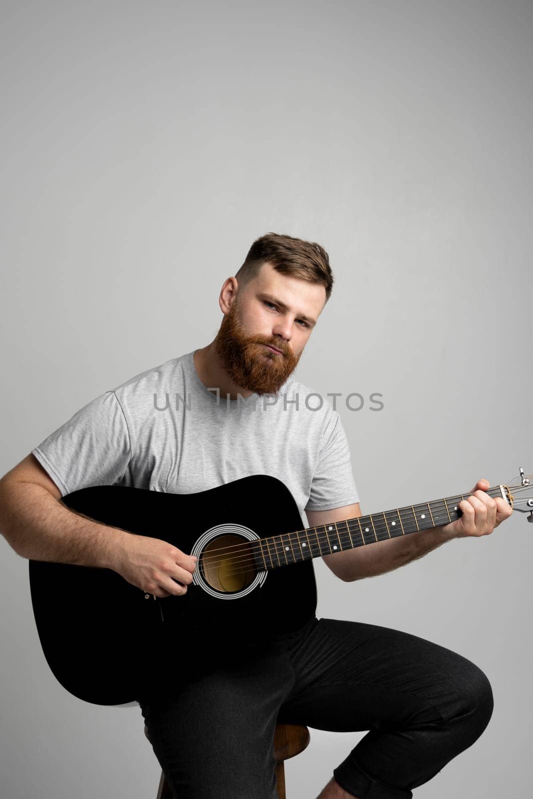 Male musician playing on acoustic guitar