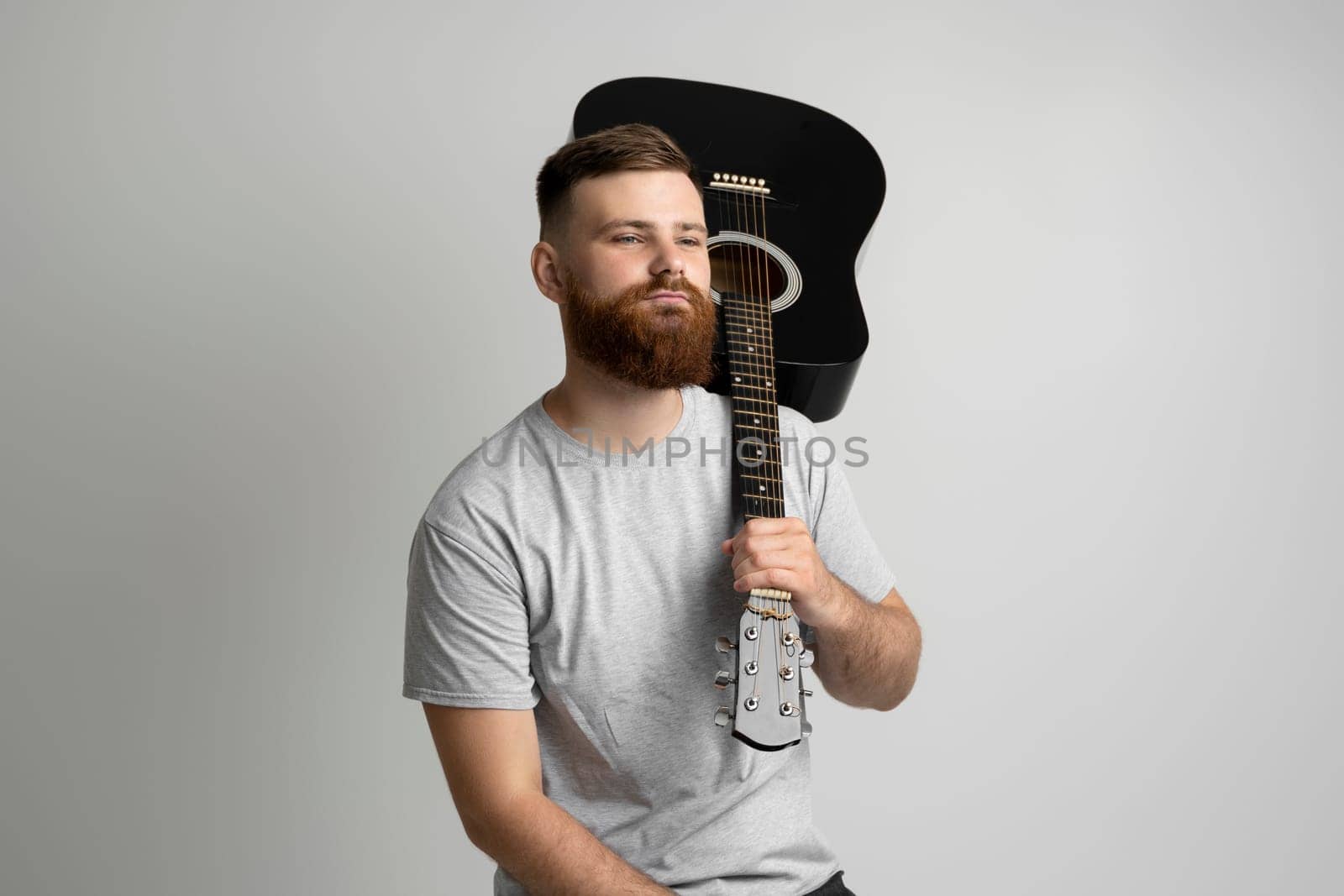 Bearded musician man having fun and playing acoustic guitar. Music performer musician. Musical string instrument