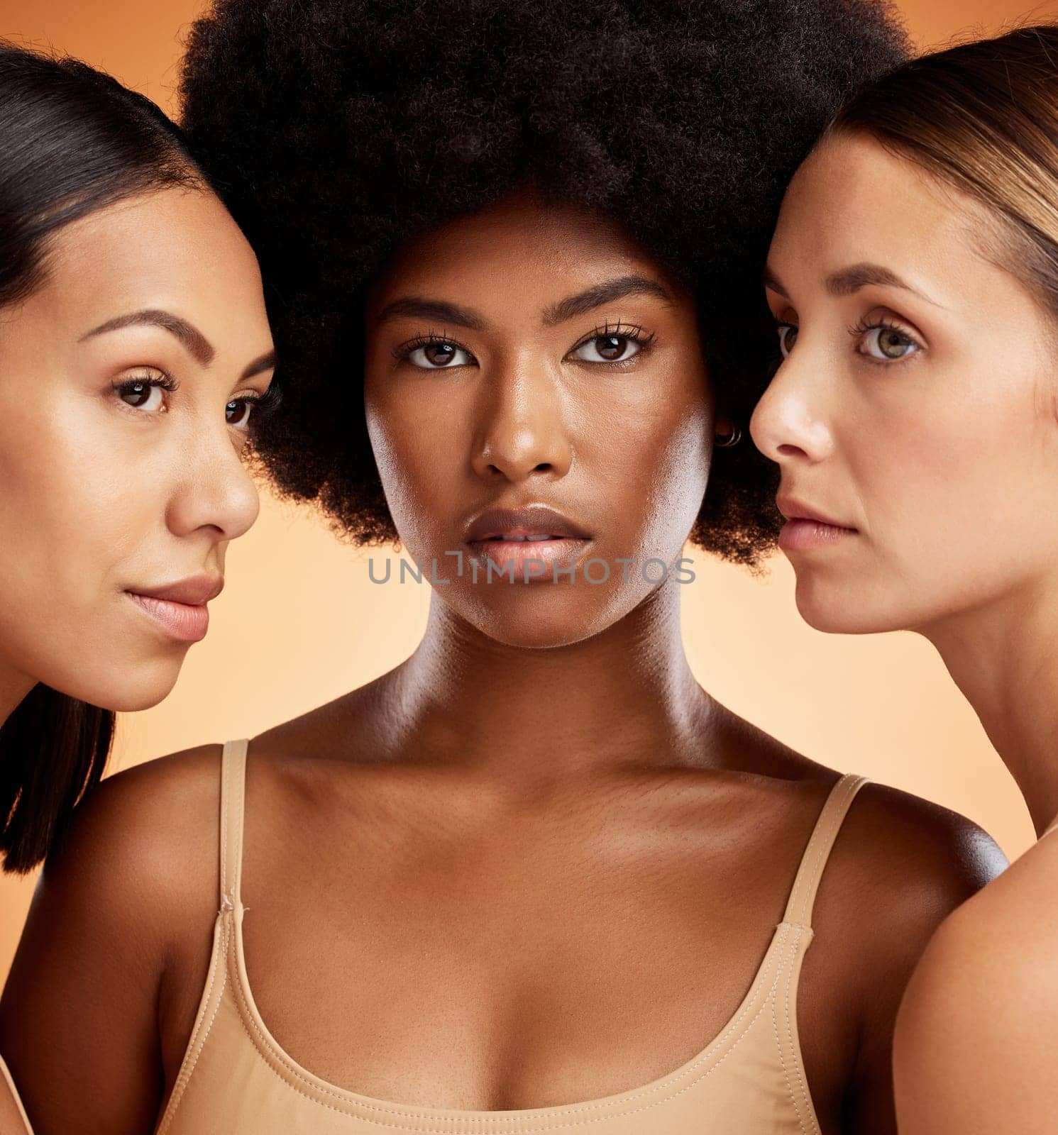 Beauty, skincare and diversity with model woman in studio on an orange background to promote a wellness product. Cosmetics, face and portrait of a female friends group posing for health and care.