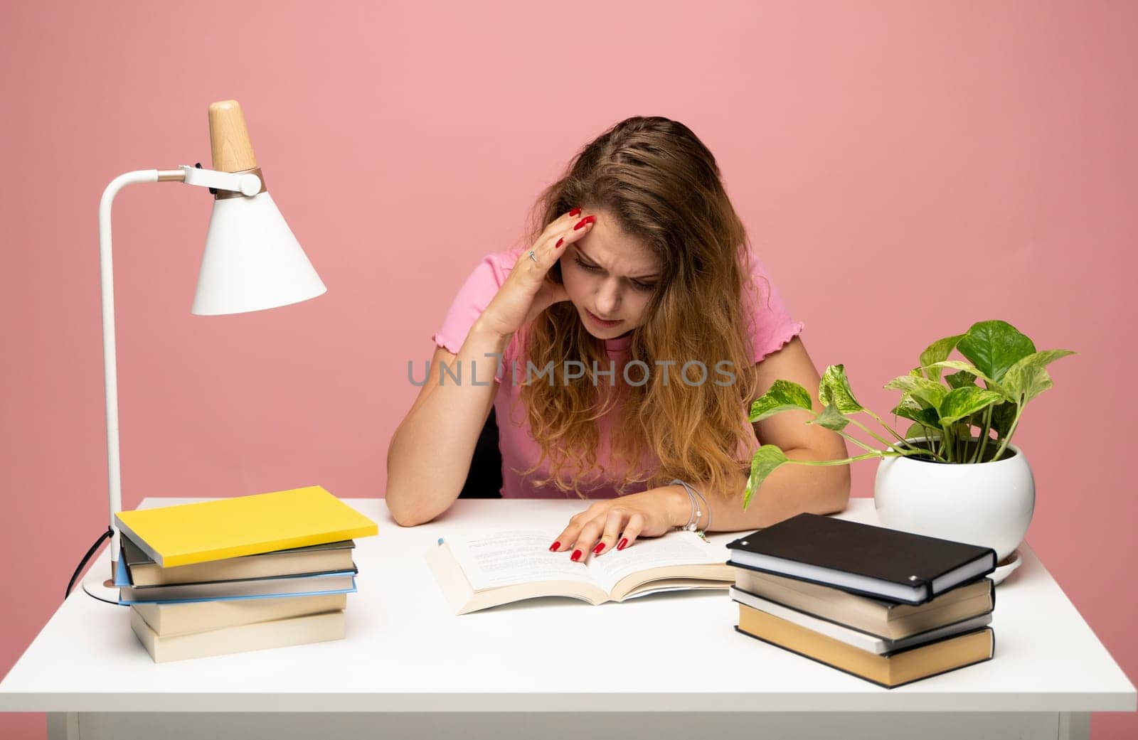 Tired student having a lot of work in a library. Too much work tired sleepy young woman sitting at her desk with books. Busy schedule in college, workplace, sleep deprivation concept