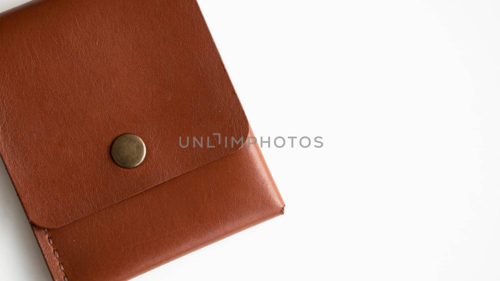 Orange genuine leather card holder on a white surface.