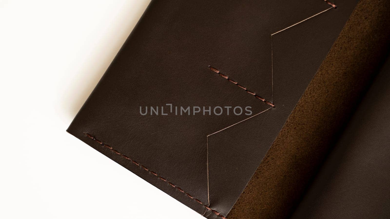 Man's handmade wallet on a white surface. Wallet made of genuine brown leather on a white background. Accessories for men