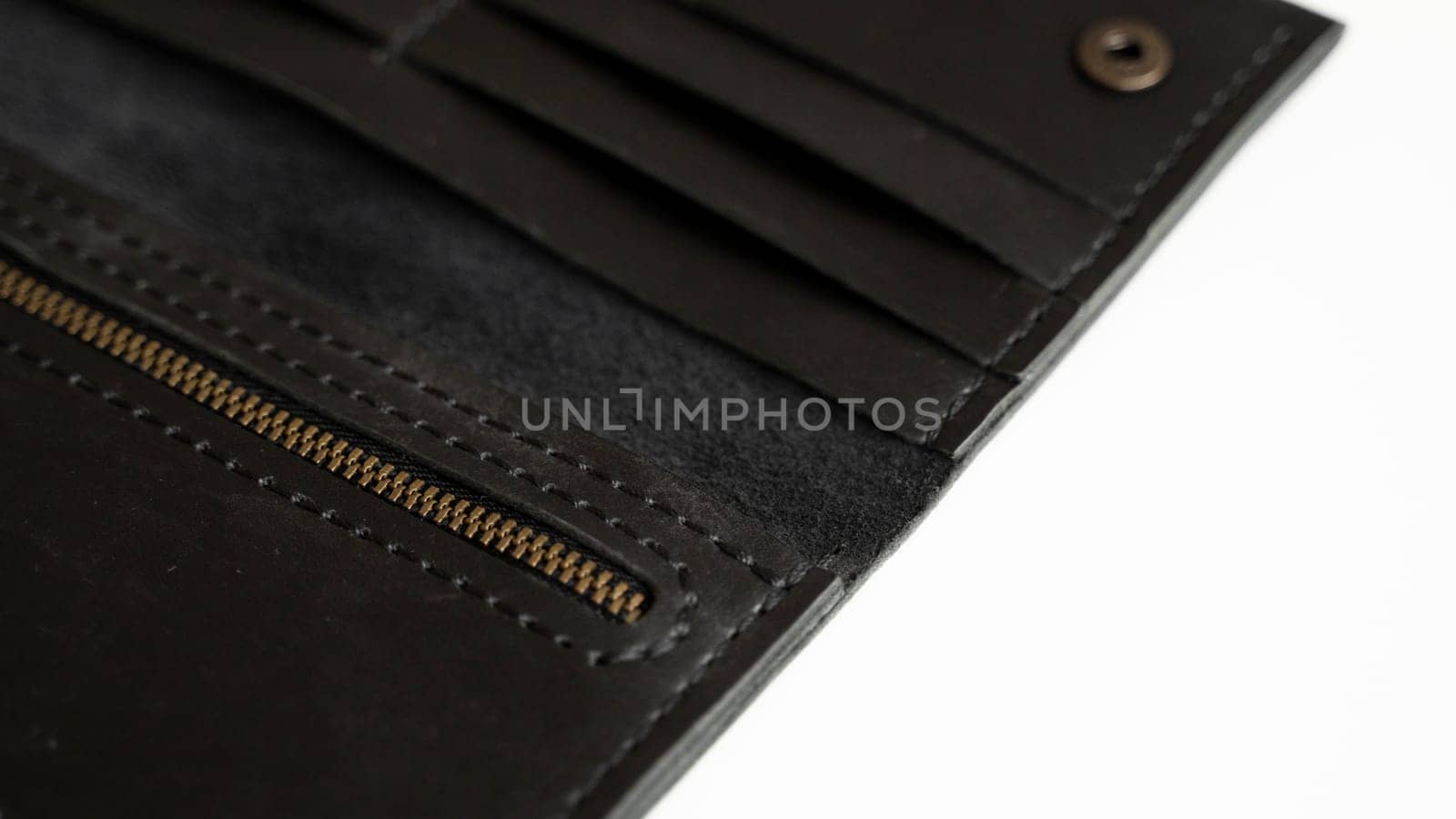 Details of open handmade brown man's genuine leather wallet with zipper on a button for banknotes and credit cards isolated on white background