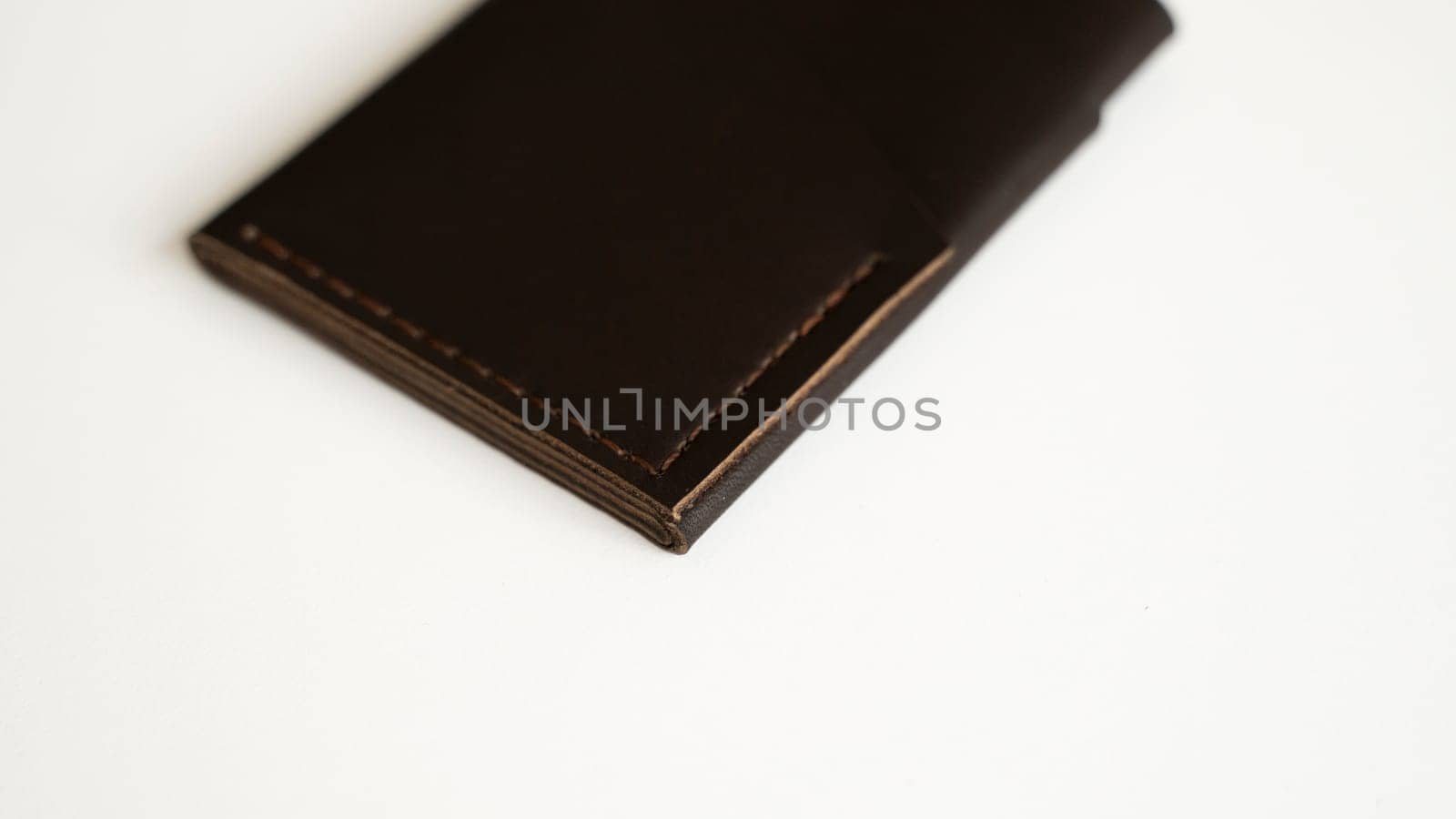 Brown empty men's business handmade leather card holder with isolated on white background. Selective focus, copy space, close up
