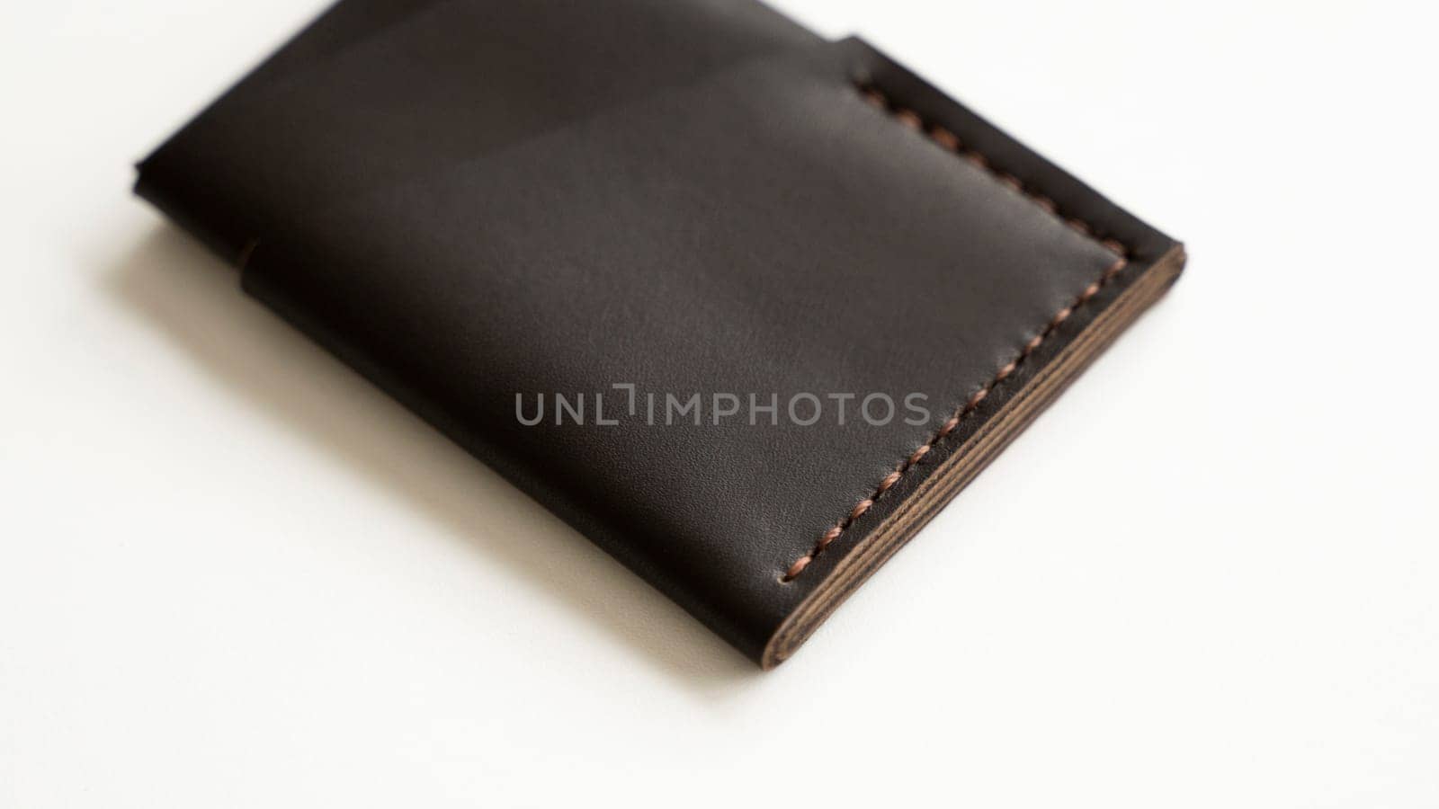 Brown empty men's business handmade genuine leather card holder with isolated on white background. Selective focus, copy space, close up. by vovsht