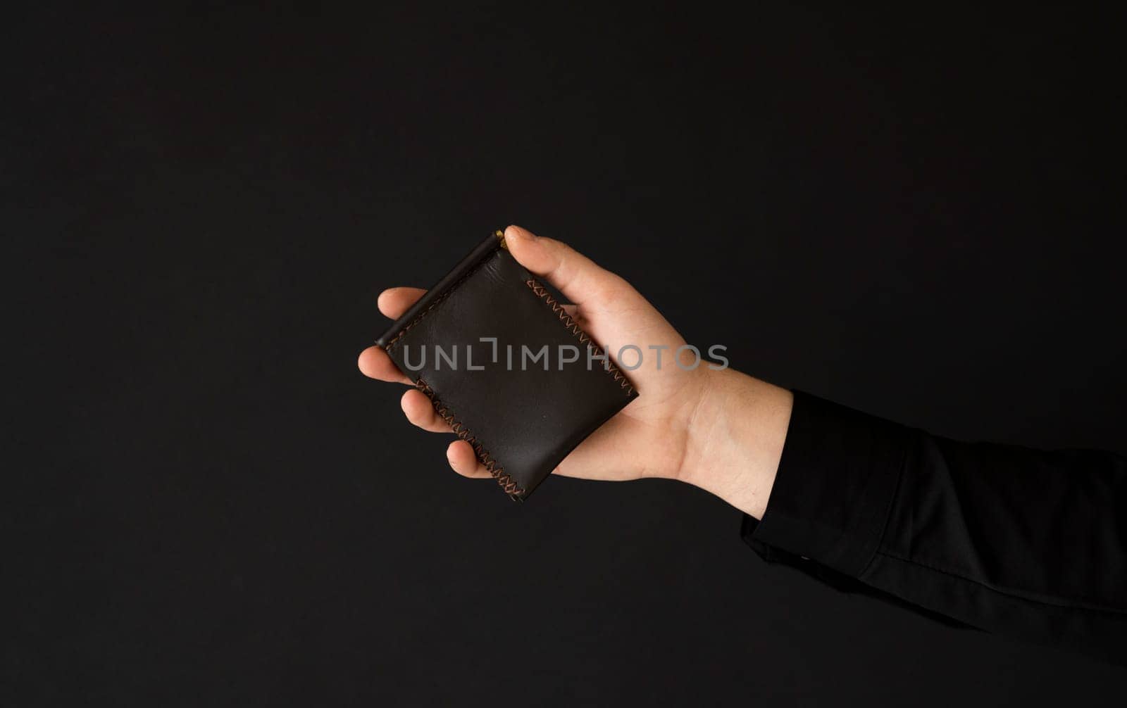 Brown empty men's business handmade leather card holder in a man's hand