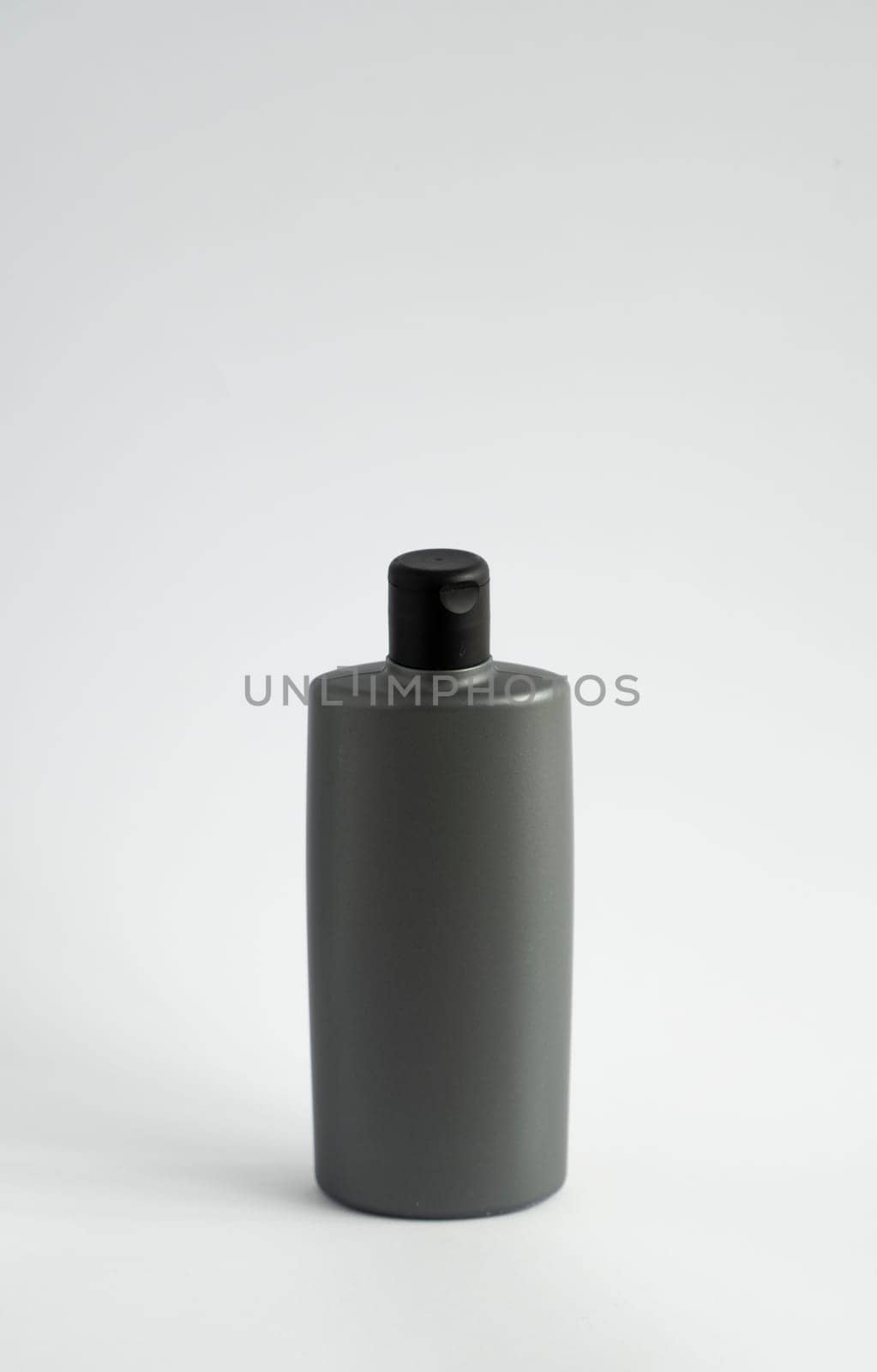 Black shampoo packaging mockup. Vertical empty plastic cosmetic package for man, isolated on white background. Container of conditioner, hair rinse. by vovsht