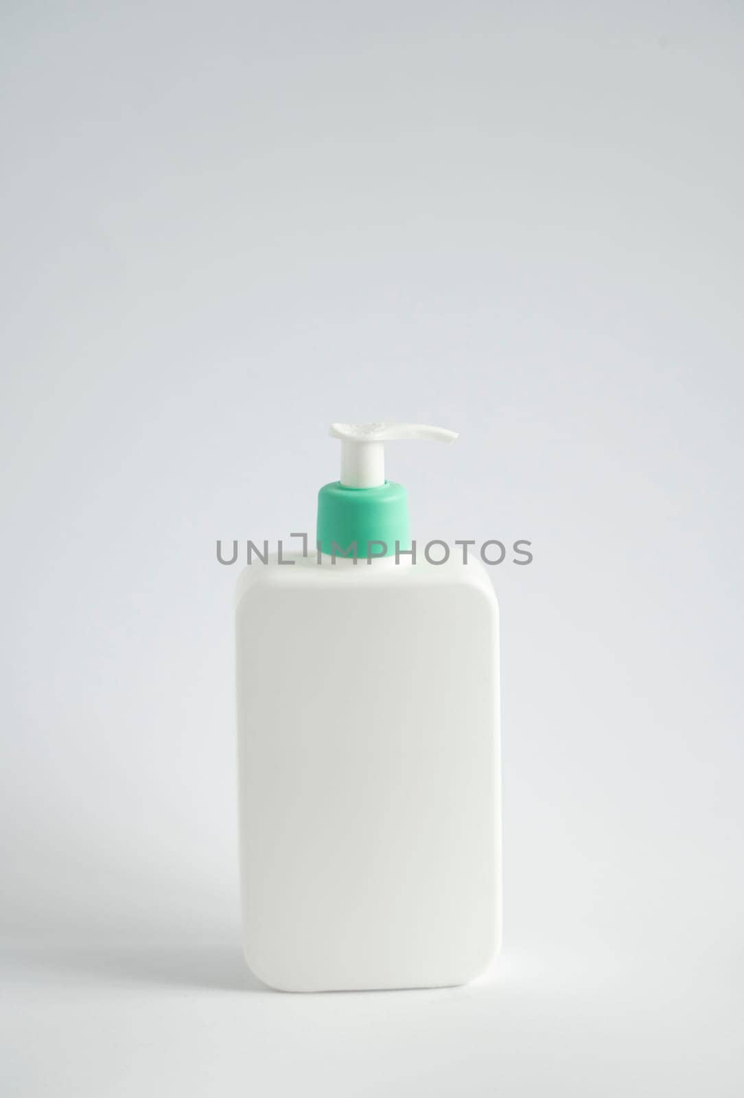White unbranded bottle with a black dispenser isolated on white background. Cosmetic packaging mockup with copy space. Bottle for a shower, gel, soap. by vovsht