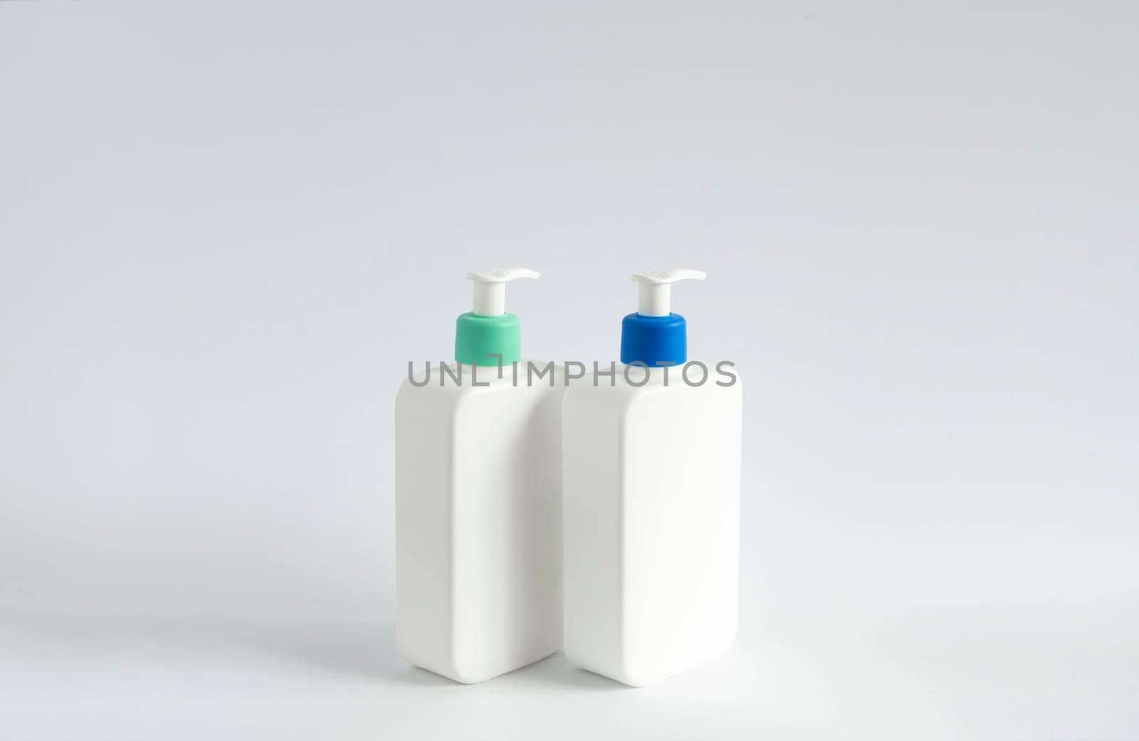 Two liquid containers for shampoo, gel, lotion, cream, bath foam etc. Blank unbranded cosmetic plastic bottles with dispenser pump