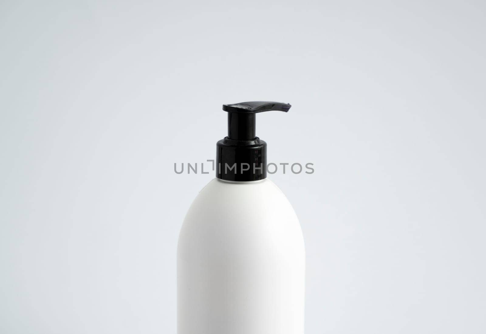White unbranded bottle with a black dispenser isolated on white background. cosmetic packaging mockup with copy space. Bottle for a shower, gel, soap. by vovsht
