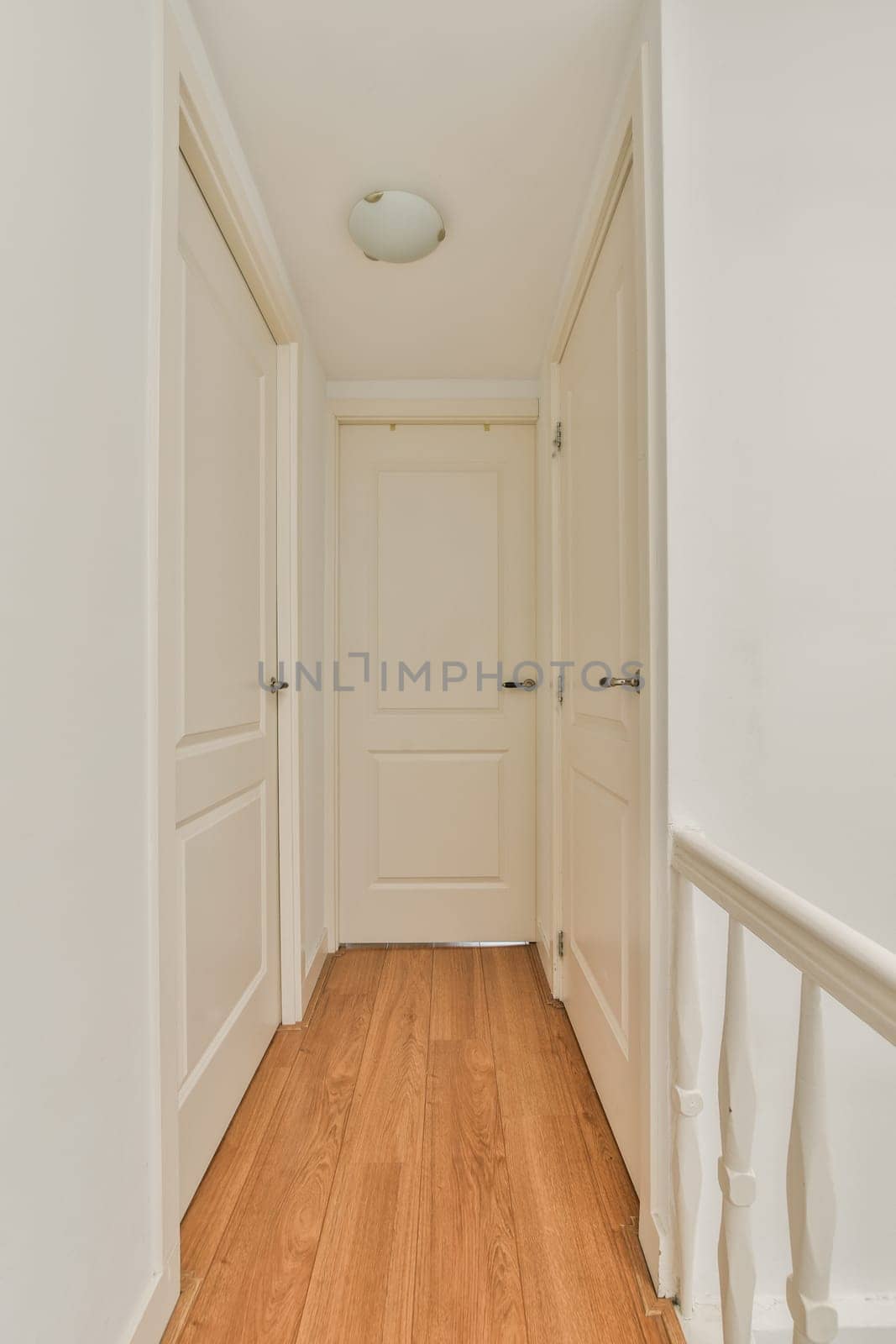 an empty room with white walls and wood flooring on the right side of the room, there is a door to the left