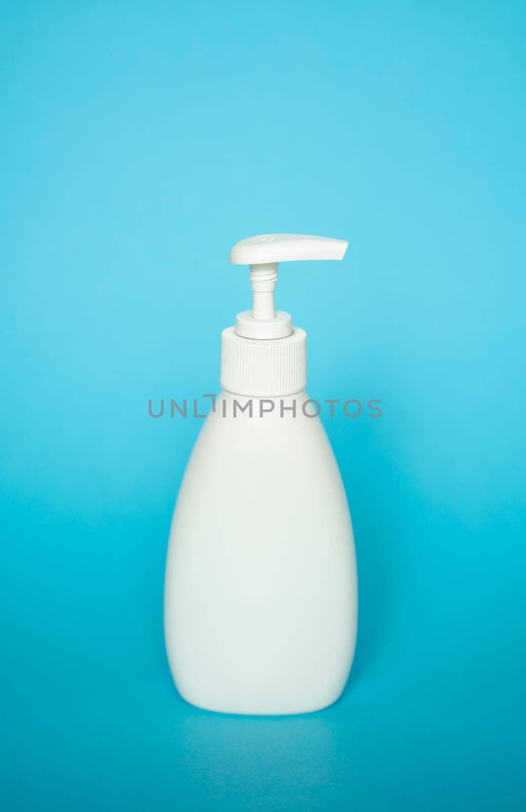 White liquid container, Cosmetic plastic bottle for gel, lotion, cream, shampoo, bath foam with dispenser pump on blue background. Cosmetic packaging mockup with copy space